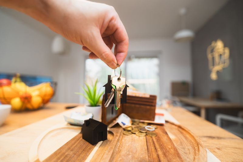 Hand holding keys in a modern rental home
